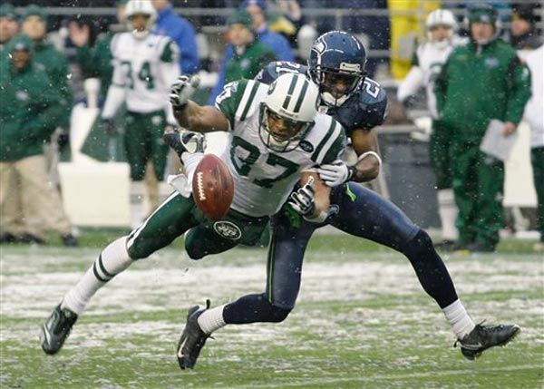 Laveranues Coles lunges for a ball as the Seahawks' Kelly Jennings breaks up a fourth-down pass play